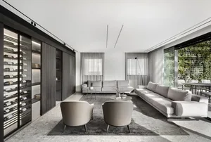 Modern living room featuring glass windows, fabric sofas, and wood accents.