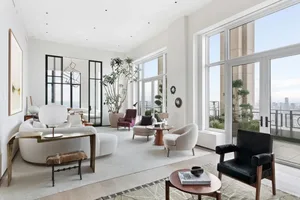A modern, minimalist living room with large windows offering stunning city views.