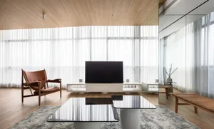 Modern living room featuring wooden floors, concrete accents, and steel furniture.
