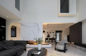 A sleek, modern living room with marble accents and a fireplace.