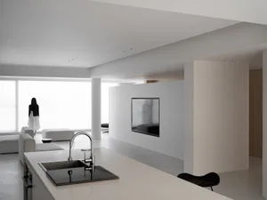 A modern minimalist kitchen featuring concrete walls and a sleek countertop design.
