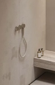 Minimalist bathroom design featuring a tiled shower with metallic fixtures.