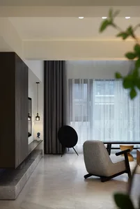 Modern minimalist living room featuring neutral-toned furniture and materials, with a comfortable seating area and minimal de