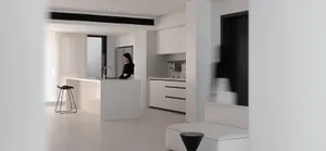 A modern minimalist kitchen with white cabinets and white countertops.