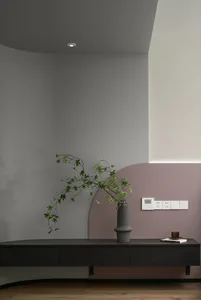 A minimalist alcove with a concrete floating planter and a sculptural greenery arrangement