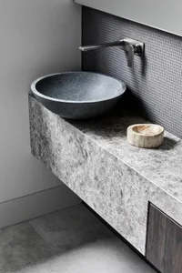 A minimalist bathroom with a granite countertop and sink.
