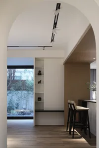 Modern kitchen with minimalist design featuring wood flooring and cabinetry.