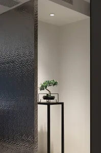 A minimalist bedroom featuring a matte black stone accent wall.