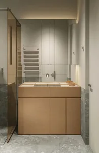 A modern bathroom interior featuring a sink mounted on a marble cabinet and a glass shower enclosure.