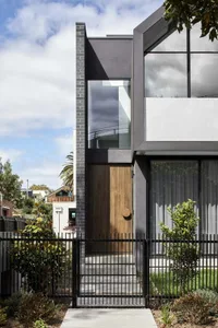 Modern house entryway featuring glass, brick, and metal elements.