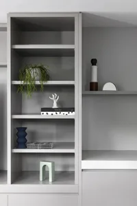 A close-up of modern, grey bookshelves with various decorative items and plants.