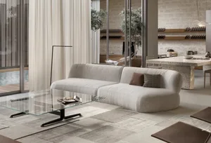 A modern living room featuring a stylish couch, glass coffee table, and minimalist decor.