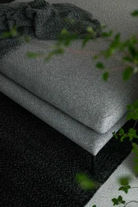 Modern living room featuring a grey sofa with fabric upholstery and black legs.