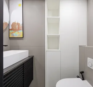 A modern minimalist bathroom with a white concrete countertop and white cabinets.