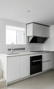 Modern minimalist kitchen with white cabinets, stainless steel appliances, and a white sink.