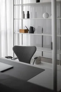 Minimalist office workspace featuring a white waterproof board and a grey office chair.