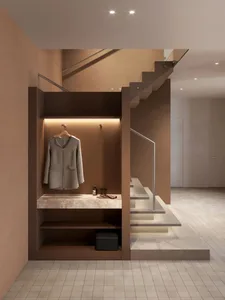 Modern interior design featuring a wooden and marble clothing storage unit beneath a staircase.