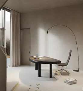 Modern minimalist office space featuring a sleek desk, chair, and floor lamp with wood and metal elements.