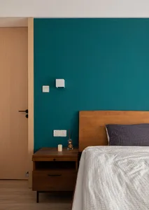 A minimalist bedroom with a wooden bed, fabric bedding, and metal accents.