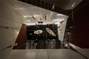 An installation of glass objects suspended in a modern interior room.