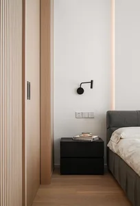 Modern minimalist bedroom featuring dark wood furniture, a gray bed, and a wall-mounted light fixture.