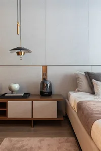 A modern bedroom featuring textured grey walls and a minimalist design.