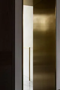A minimalist interior design featuring a metallic brass door.