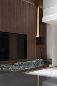 A modern interior space featuring wooden panels, leather furniture, and marble countertops.