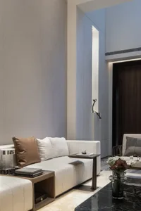 A modern living room featuring fabric upholstery, concrete accents, and marble finishes.