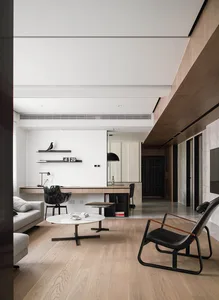 A modern living room featuring wooden flooring and a marble countertop.