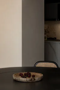 現代簡約室內設計，展示一張圓形白色木桌，搭配簡潔優雅的藤編椅。