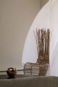 Minimalist living room with a wooden armchair and a fabric curtain