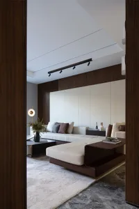 Modern, minimalist living room featuring a white sofa, black coffee table, and white and brown decorative elements, all set a
