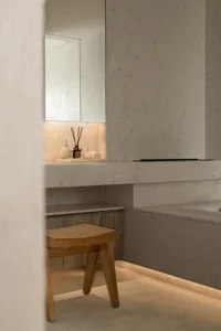 A modern, minimalist bathroom with marble finishes and underlit shelves.