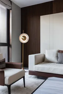 A modern living room featuring wood-paneled walls, white sofas with brown accents, and sleek, minimalist furnishings.
