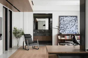 Contemporary living room with minimalist design, featuring a black chair, a large abstract painting, and a combination of whi