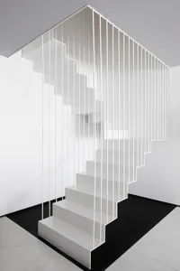 A modern, minimalist metal staircase with white steps and railings.