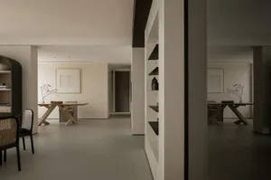 現代住宅餐廳，配有木質餐桌與黑色餐椅、簡約裝飾，以及牆面置物架