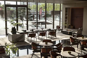 Interior view of a modern coffee shop featuring marble countertops and wooden furniture.