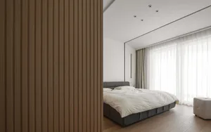 Minimalist bedroom with wooden walls and a comfortable bed.