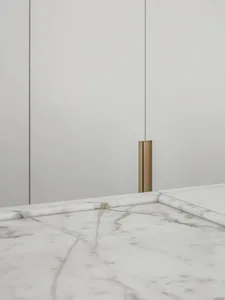 A minimalist modern interior design featuring marble surfaces with subtle gold accents.