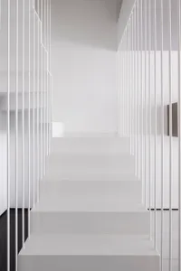 A minimalistic, modern staircase with white railings and steps.