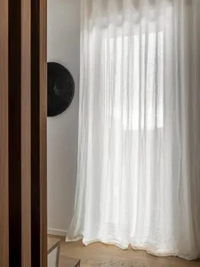 White linen curtains hanging on a window