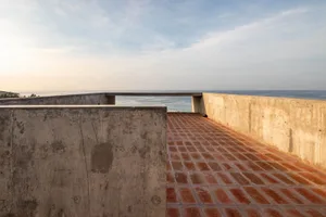 Concrete patio with brick walkway overlooking the ocean.