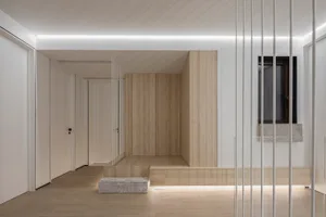 A minimalist residential entryway featuring wooden paneling and a large window.
