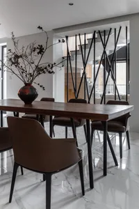 A modern dining room with wooden table, leather chairs, glass vase, and minimalist design.