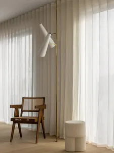 Minimalist living room with white curtains, wooden chair, and white floor lamp