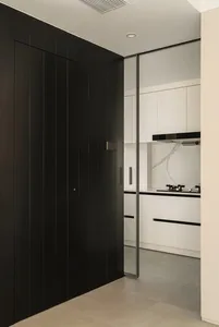 Modern minimalist kitchen featuring glossy white marble countertops and white cabinets with black accents.