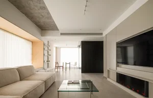 A modern contemporary living room featuring a minimalist design with a concrete ceiling, light-colored sofa, and glass coffee