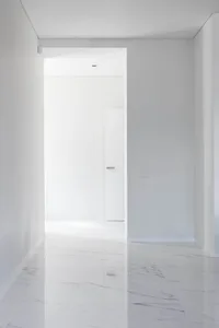 A minimalist, modern interior featuring a marble flooring and white walls.